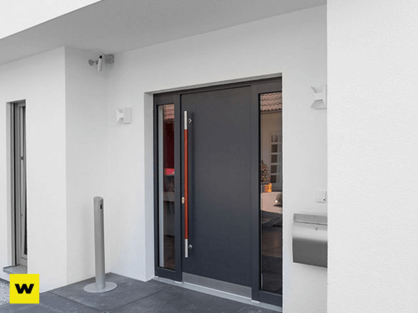 Moderne Haustür aus Aluminium mit seitlichem Glaselement an weißer Hausfassade.